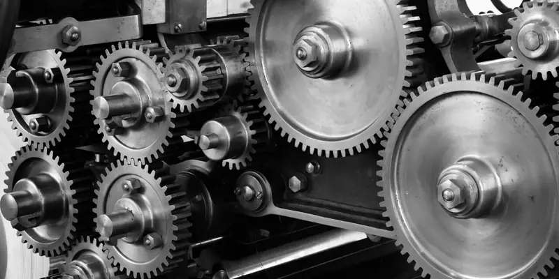 Image of metal cogs and gears as part of a larger machine