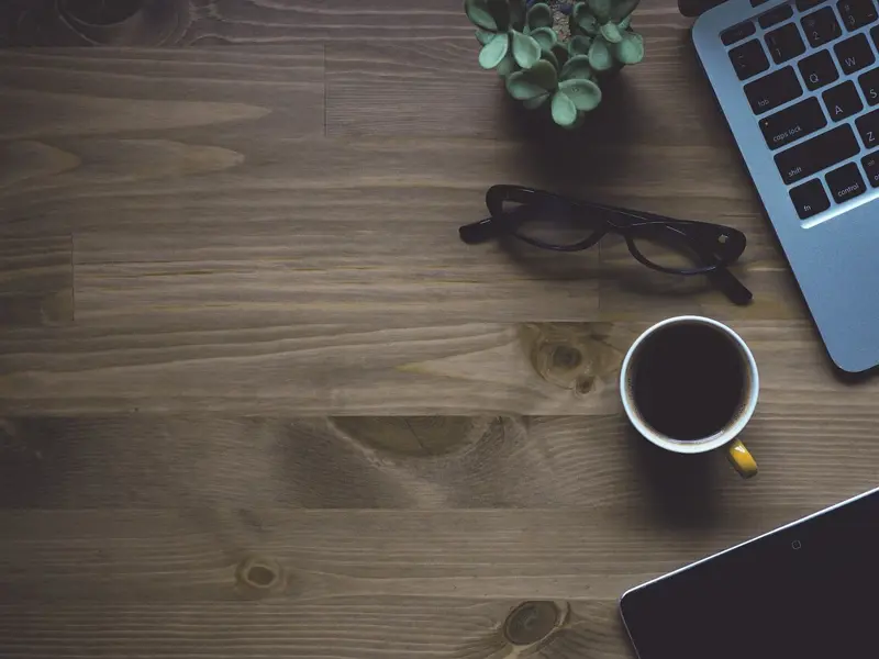 Image of a laptop computer and a cup of coffee on a wooden table