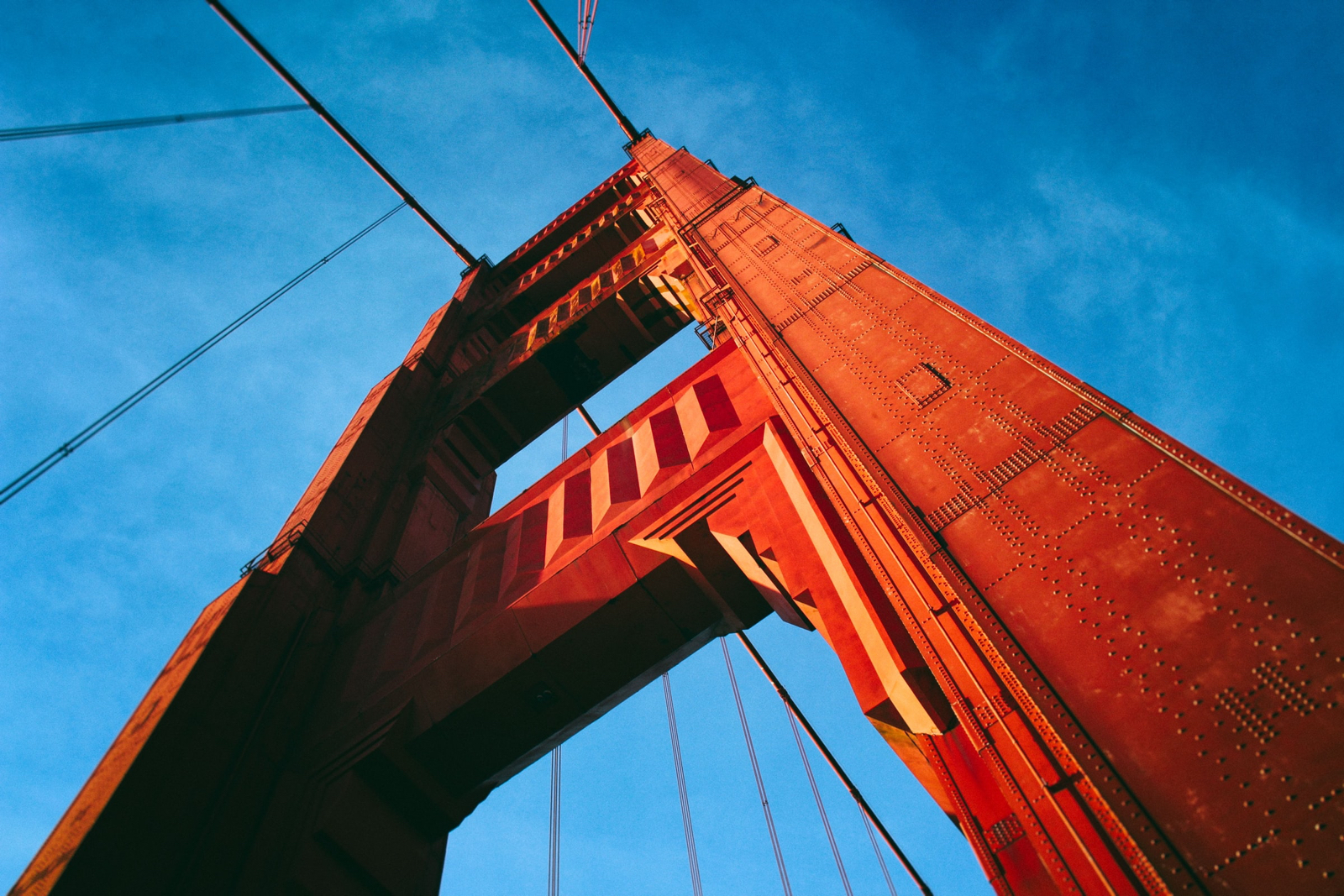 Close up image of the pillar of a bridge taken against a bright blue sky