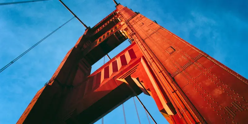 Close up image of the pillar of a bridge taken against a bright blue sky