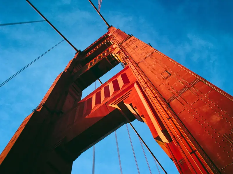Close up image of the pillar of a bridge taken against a bright blue sky