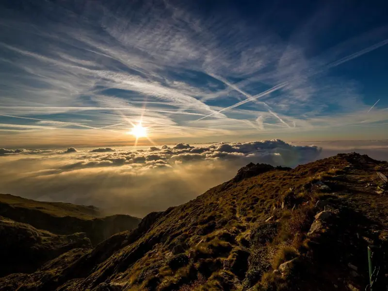 Image showing a range of mountains in the distance with blue sky, hazy clouds and a weak sun shining through