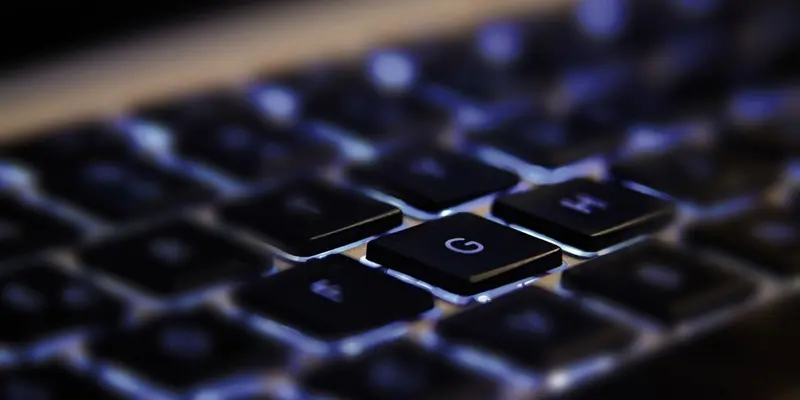 Abstract image showing a closeup of computer keys which are backlit from underneath
