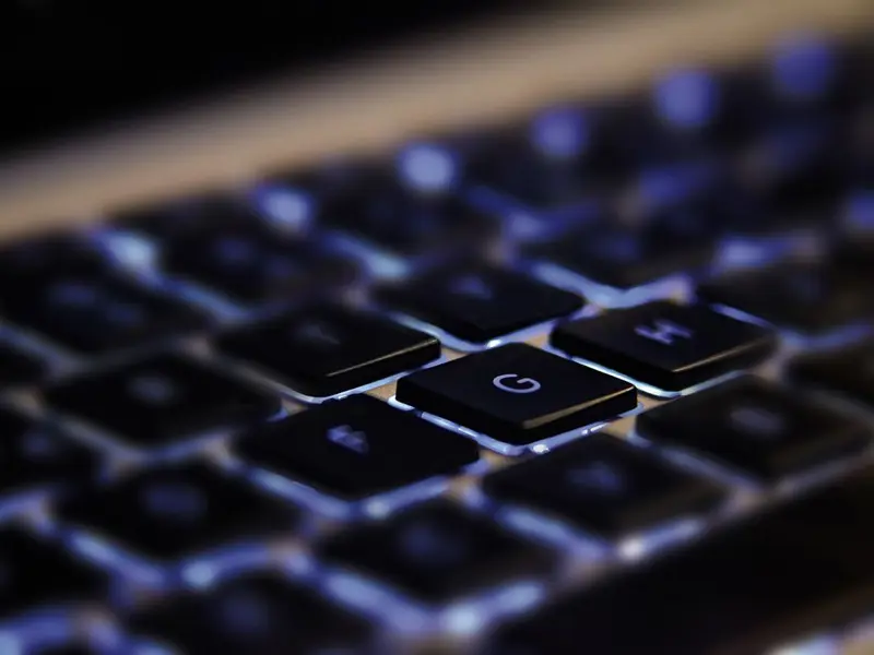 Abstract image showing a closeup of computer keys which are backlit from underneath