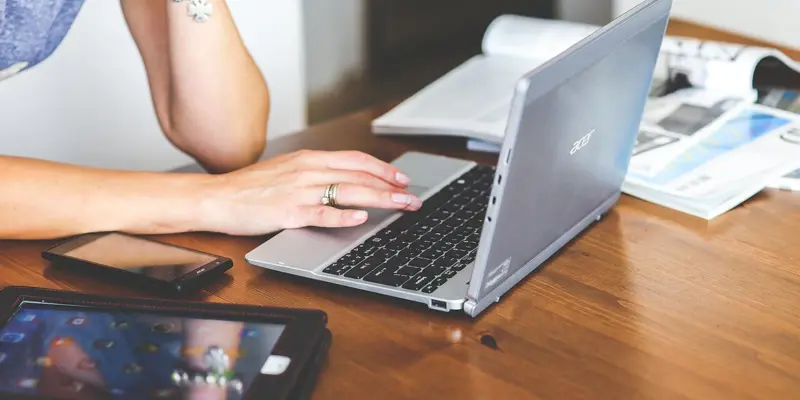 Image showing a woman leaning on a table and working on a laptop computer