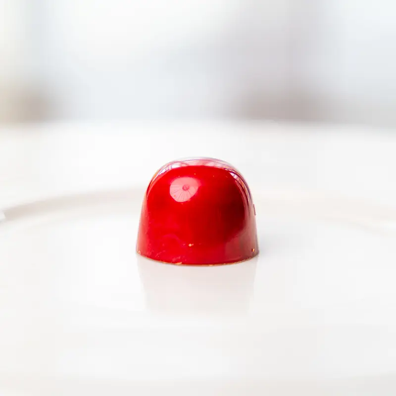 alt="Håndlaget sjokolade med bringebær og hockeypulver – søtt, syrlig og salt i perfekt balanse"